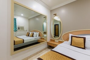 Ein Hotelzimmer mit einem Bett, einem Nachttisch, einem Spiegel und einer Wand-Klimaanlage.