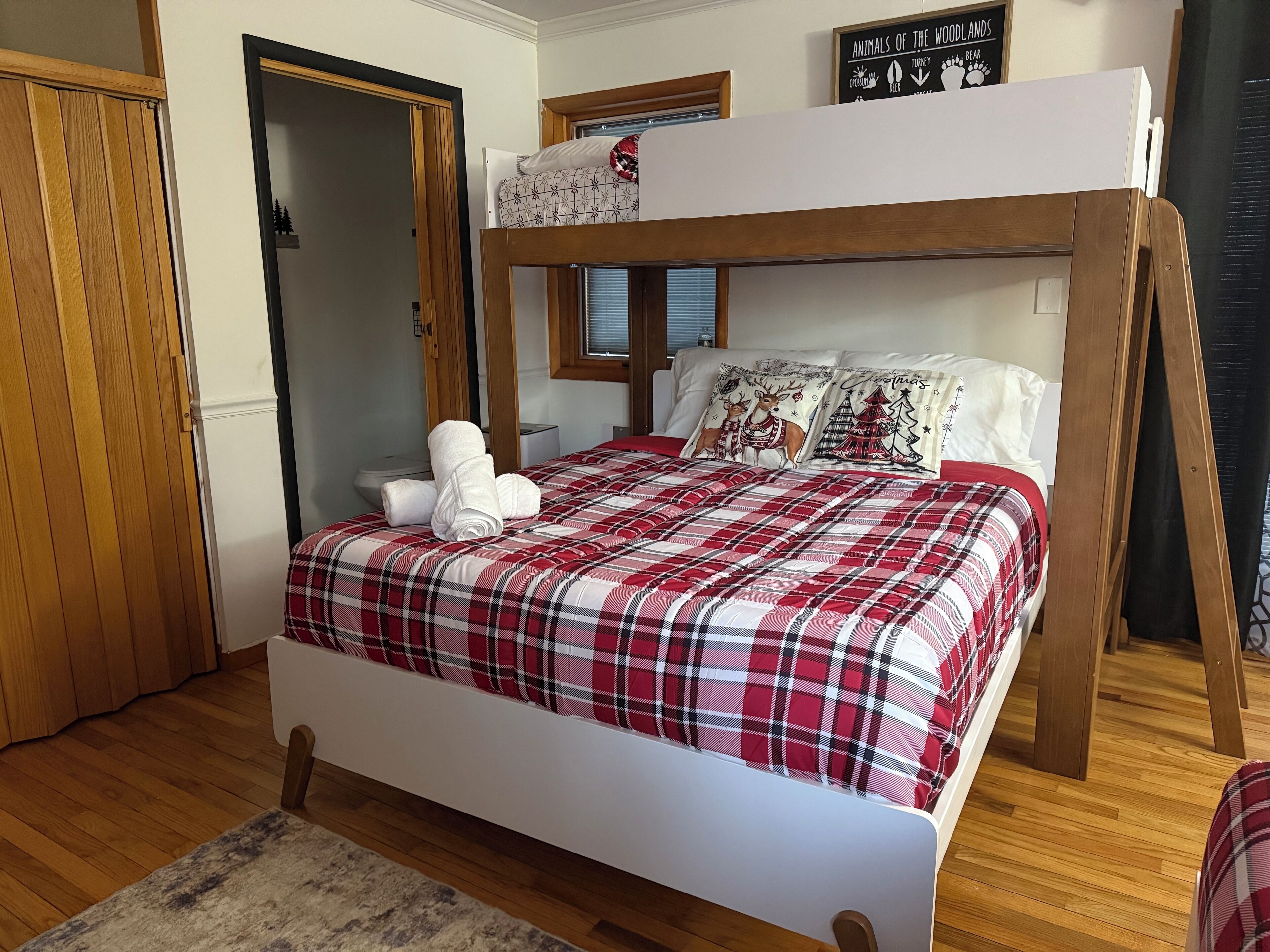 Un dormitorio con literas, un armario de madera, un baño y un cartel sobre animales de zonas silvestres.