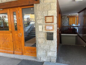 A wooden entrance door with a glass panel, a stone wall with a plaque, and a sign indicating a ski area. - Ski-In/out | Steps to Morel Lift | Fully Equipped  | Washer/Dryer  | La Frasse (Les Allues)