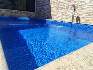 A swimming pool with clear blue water, a tiled edge, and a metal ladder. - High-end house with swimming pool and 3 bedrooms (Plano Diretor Sul Palmas)