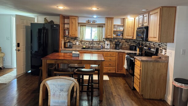 A kitchen with wooden cabinets, a central island, and a refrigerator.