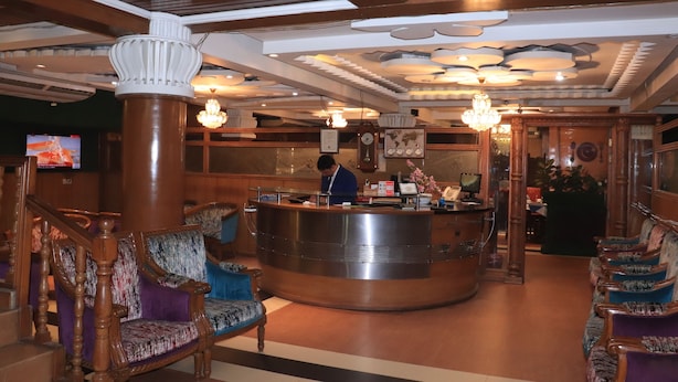 A lobby with a reception desk, wooden furniture, and a chandelier. - Sea Shell Hotel & Restaurant (Dhaka)