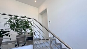 A modern staircase with metal railings and granite steps, leading to an upper floor. - Dariana Schwalbach/Saar (Schwalbach)
