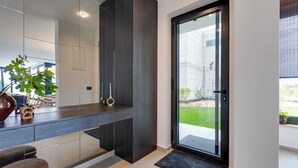 Una cocina moderna con armarios oscuros, un ventanal y vistas a una obra en construcción.