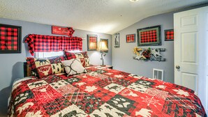 A bedroom with a large bed, a nightstand, a lamp, and a door. - 1 Mi to Hatfield-McCoy Trails: Apt in Matewan (Matewan)