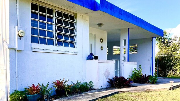 A single-story building with a blue roof and white walls.