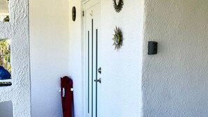 A white door with a keyhole and a doorbell.