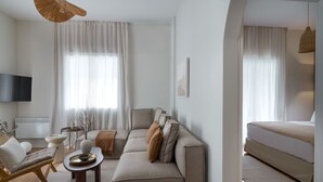 Ein modernes Wohnzimmer mit einer Couch, einem Couchtisch und einem Fernseher.