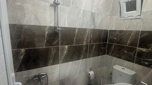 A bathroom with a shower, toilet, and sink. - maldivler pansiyon (Yesilova)