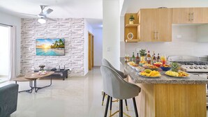 A modern kitchen with granite countertops, wooden cabinets, and a dining area with a table and chairs.