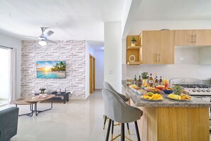 A modern kitchen with granite countertops, wooden cabinets, and a dining area with a table and chairs.