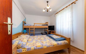 A room with bunk beds, a desk with a computer, a lamp, and a television. - 1 bedroom awesome apartment in Razanac (Razanac)