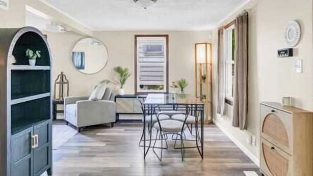 A modern living room with a dining area, a sofa, a coffee table, and a TV.