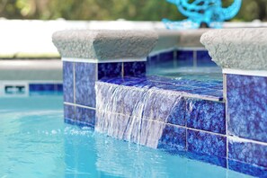 A pool with blue mosaic tiles and a stone ledge. - Miranda Villa Close to Disney! Relax & Recharge after Park Fun (Davenport)