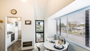A compact kitchen with white cabinets, a built-in oven, and a dining area with a table set for two.