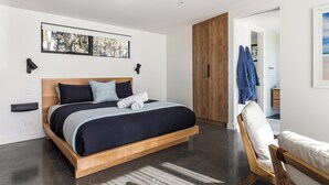 A modern bedroom with a wooden bed, a view of trees through a window, and a wooden wardrobe. - Chalet Coast | Walburra Brook Off-grid Luxury stay (Metricup)