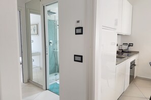 A modern kitchen with white cabinets, a stainless steel countertop, and a built-in oven. - Exclusive Penthouse, Sea View, 100m from the beach (Alassio)