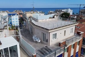 A rooftop terrace with a table and chairs, a balcony, and a view of the sea. - Exclusive Penthouse, Sea View, 100m from the beach (Alassio)
