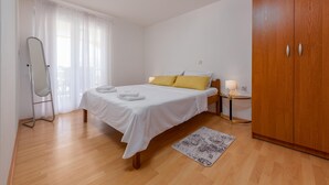 A bedroom with a bed, a wooden wardrobe, a bedside table with a lamp, and a mirror. - 1 bedroom awesome apartment in Seline (Seline)