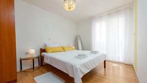 A bedroom with a bed, bedside table, lamp, and a mirror. - Nice apartment in Seline with WiFi (Seline)