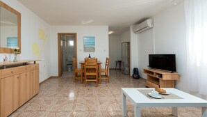 A modern living room with a dining area, a TV, and a kitchen. - Nice apartment in Seline with WiFi (Seline)