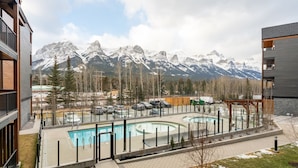 A modern building with a pool area, surrounded by snow-capped mountains. - Designed Specifically for Large Families (Canmore)