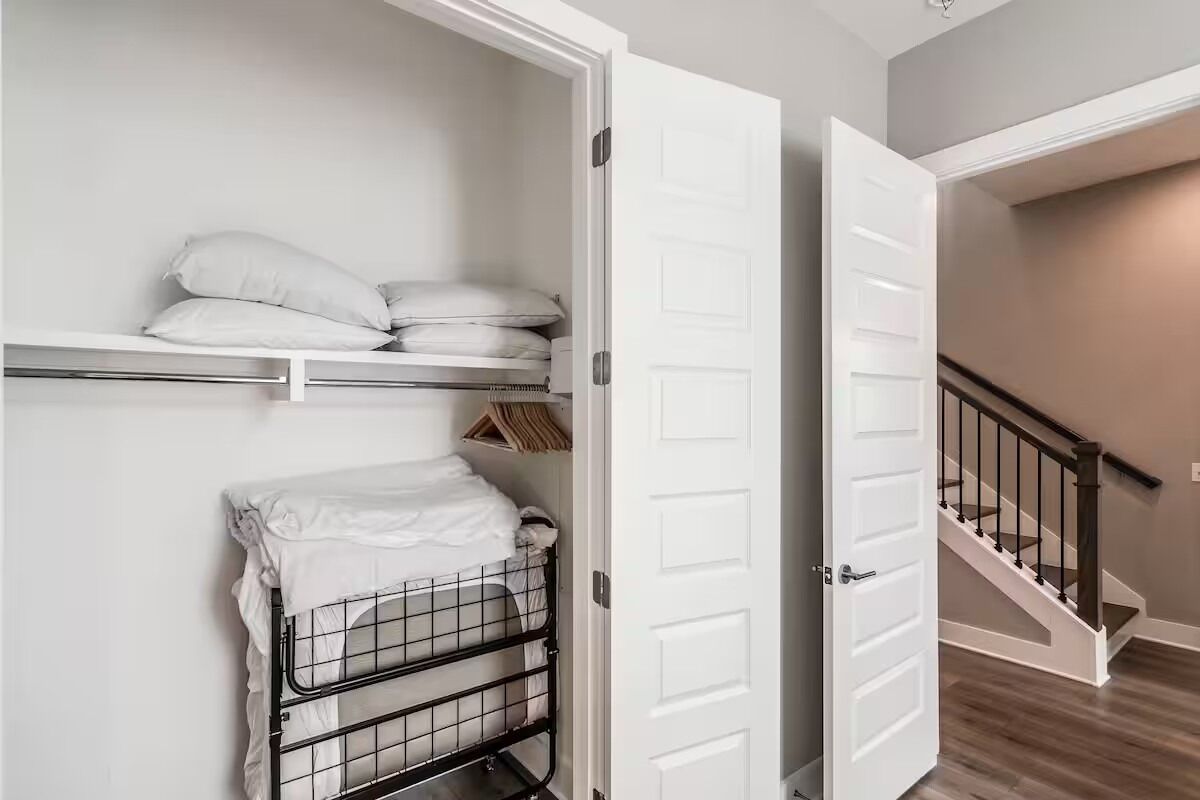 Quarto com beliche, porta branca e escada.