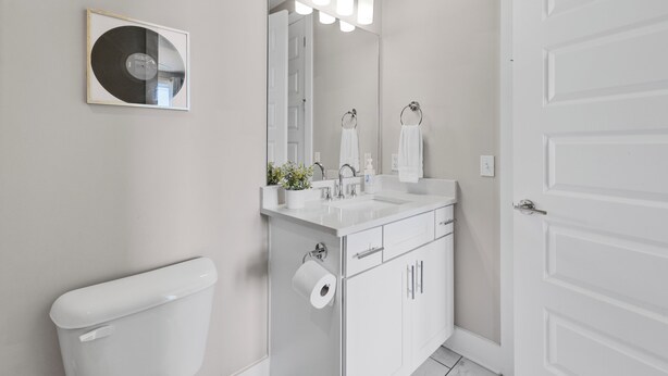 A modern bathroom with a toilet, sink, and mirror. - TheNashpad! Rooftop, Games, 5 mins to Broadway! (Nashville)