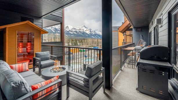 A balcony with a fire pit, seating, and a grill. - Luxury 8-BR Family Home with Exceptional Amenities (Canmore)