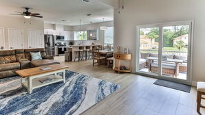 Un salón amplio con una mesa de centro grande, un sofá y vistas al área de cocina y comedor.
