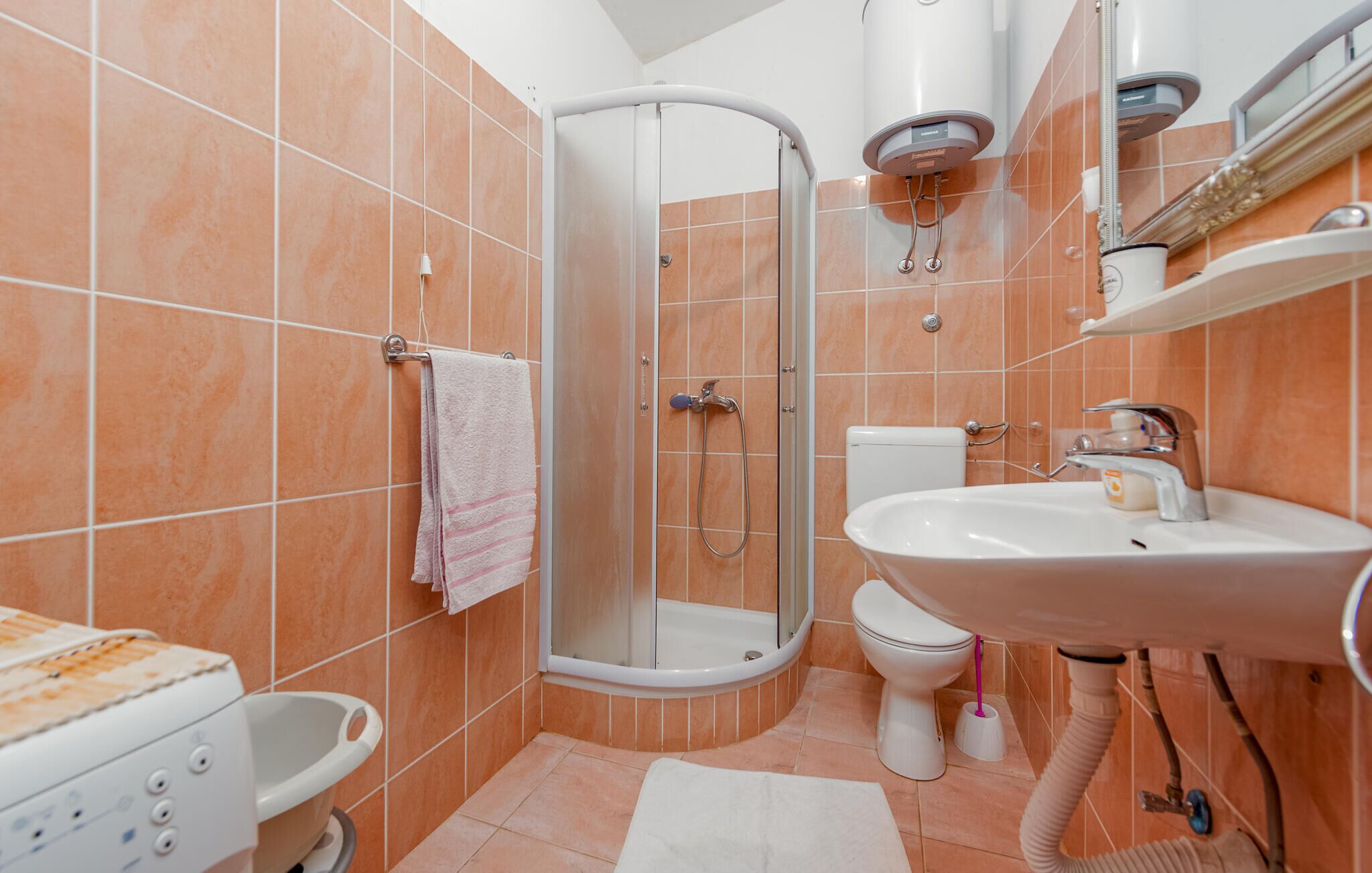 Een badkamer met douche, toilet, wastafel en een bad.