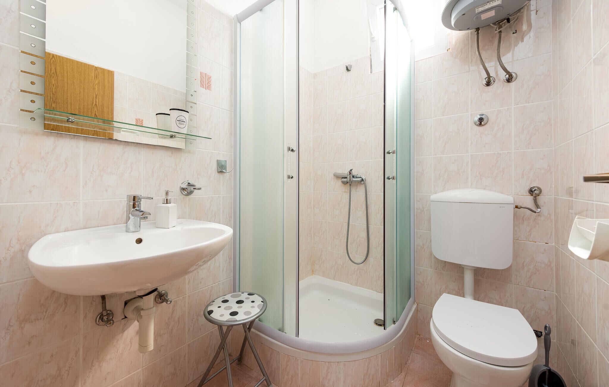 Une salle de bain avec une douche à parois de verre, un lavabo et des toilettes.
