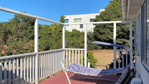A wooden deck with a red floor, white railings, and a hammock.