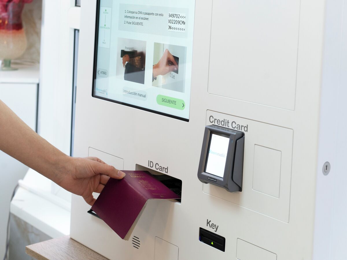 En person som för in ett ID-kort i en maskin med en skärm som visar instruktioner.