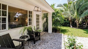 A house with a patio area featuring a seating arrangement and a decorative light fixture.