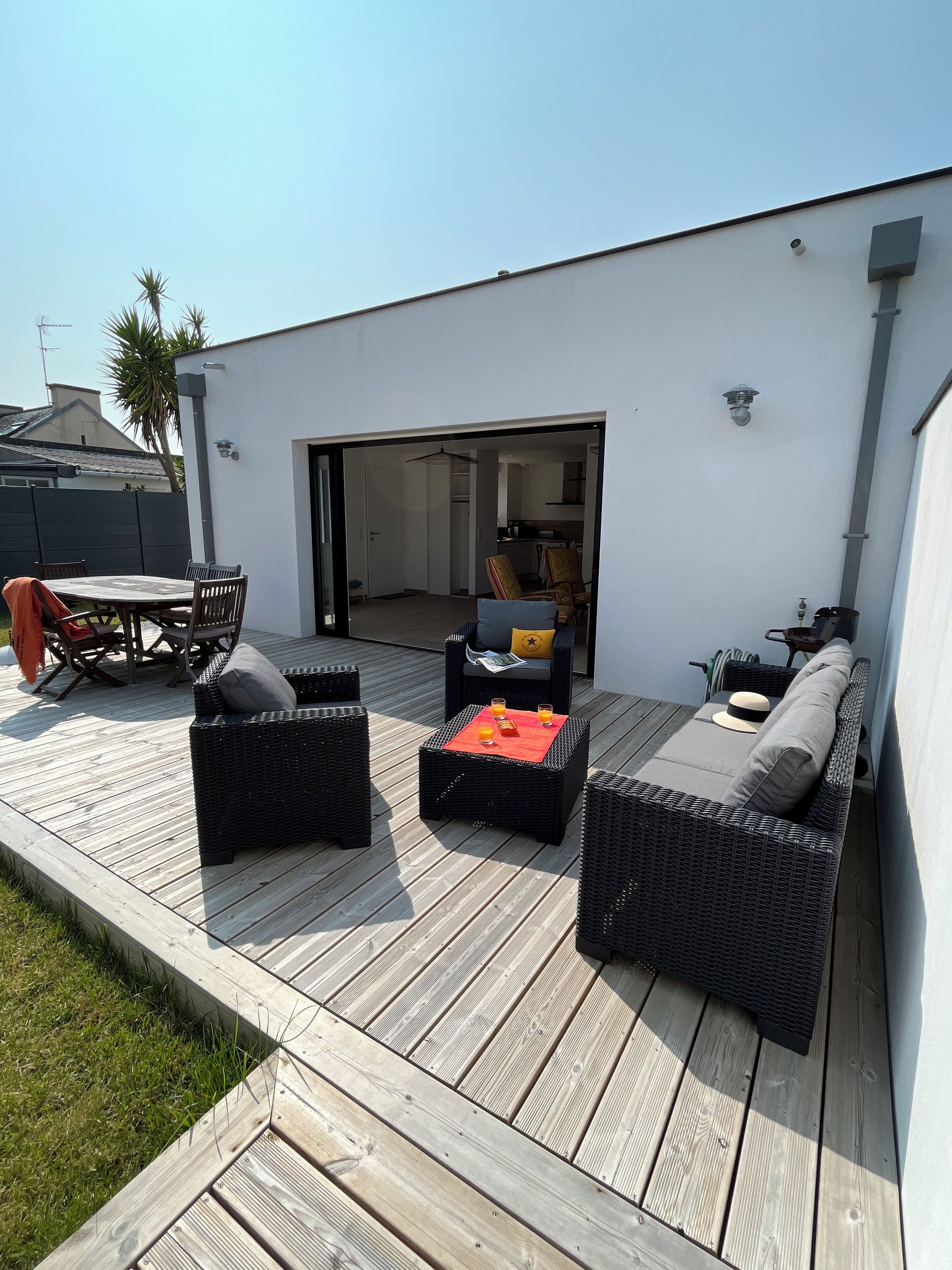 An outdoor patio with wicker furniture, a table, and chairs.