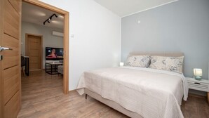 Une chambre à coucher avec un lit, une télévision, un bureau et une chaise.