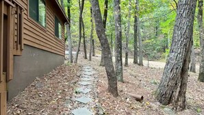 A wooden cabin with a stone pathway leading through a forest. - Mountain View’s with hot-tub (Jasper)