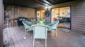 A covered patio with wicker furniture and a grill. - Mountain View’s with hot-tub (Jasper)
