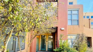 A building with a modern architectural style, featuring a red facade and a glass entrance. - Spacious Design Loft/Railyard Distr; soaking tub (Santa Fe)