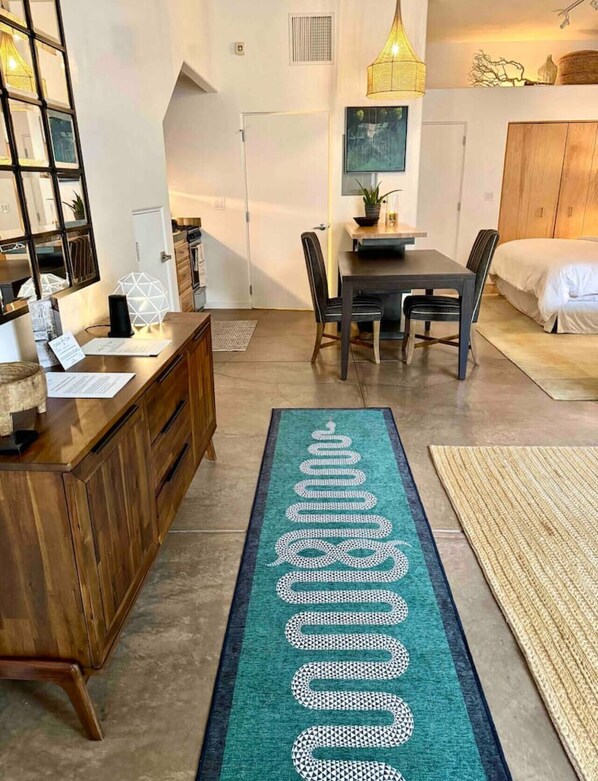 A modern bedroom with a bed, a desk, and a dining area.