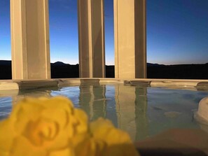 Un jacuzzi con una vista despejada del cielo y montañas al fondo.