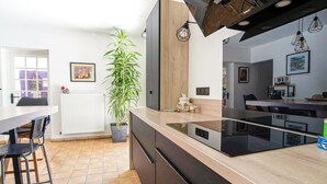 A modern kitchen with a central island, black appliances, and a large potted plant. - Lovely home in Saint Cezaire (Saint Cezaire)