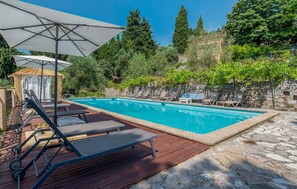 A rectangular swimming pool with a stone border, surrounded by a wooden deck and lounge chairs. - Lovely home in Grasse with house sea view (Grasse)