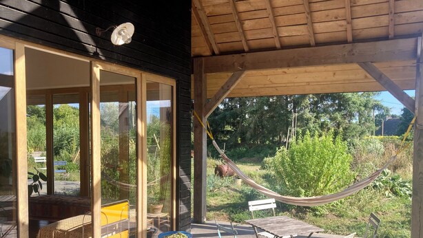 Un pont de fusta amb una cadira balancí, seients plegables i una taula.