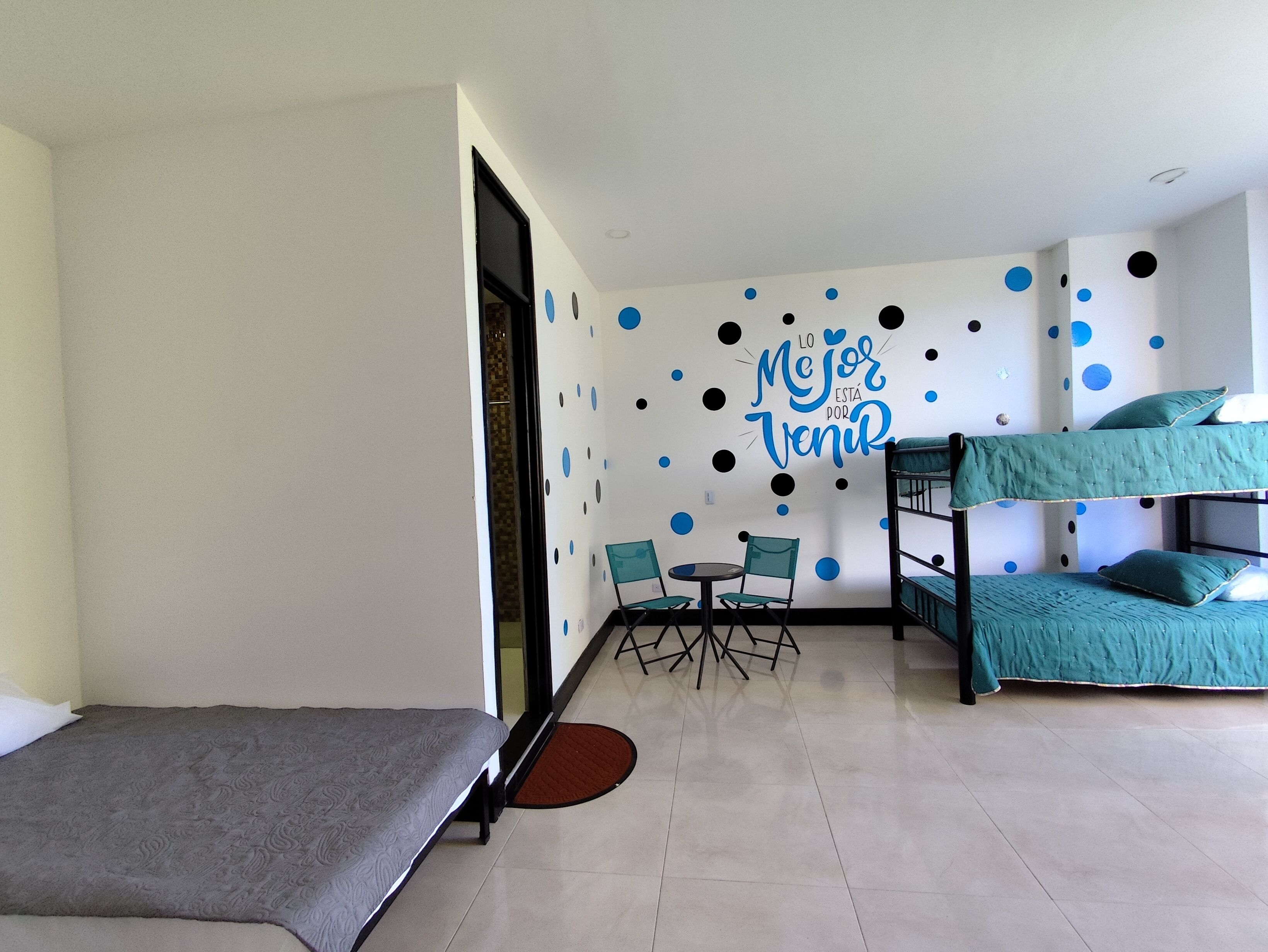A room with bunk beds, a desk, and chairs.