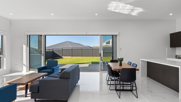 A modern kitchen with dark cabinetry and a large island, a dining area with a wooden table and chairs, and a living room with a sofa and a coffee table. - Cork & Vine on Coolalta  - A Cellar Door Escape (Nulkaba)