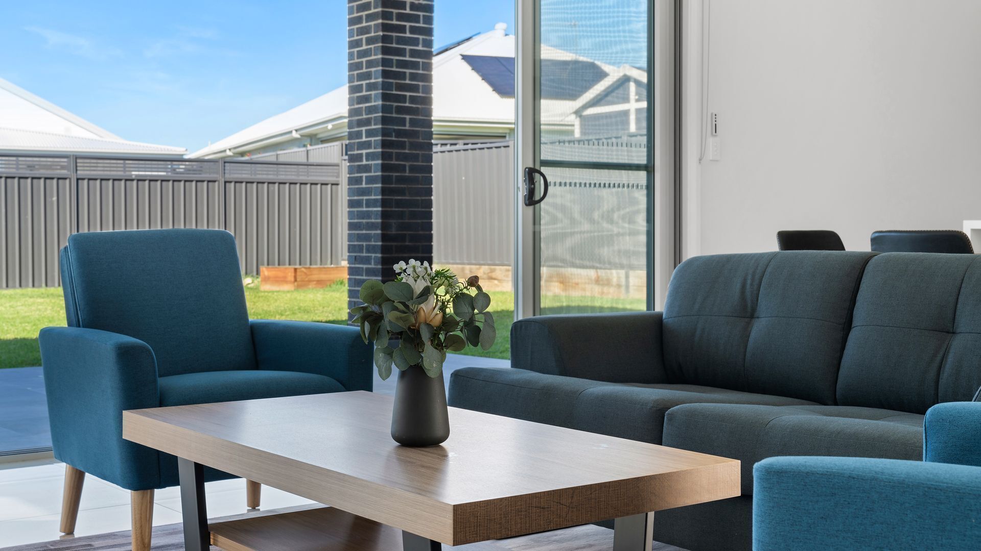 Een moderne woonkamer met een bank, een fauteuil en een salontafel.