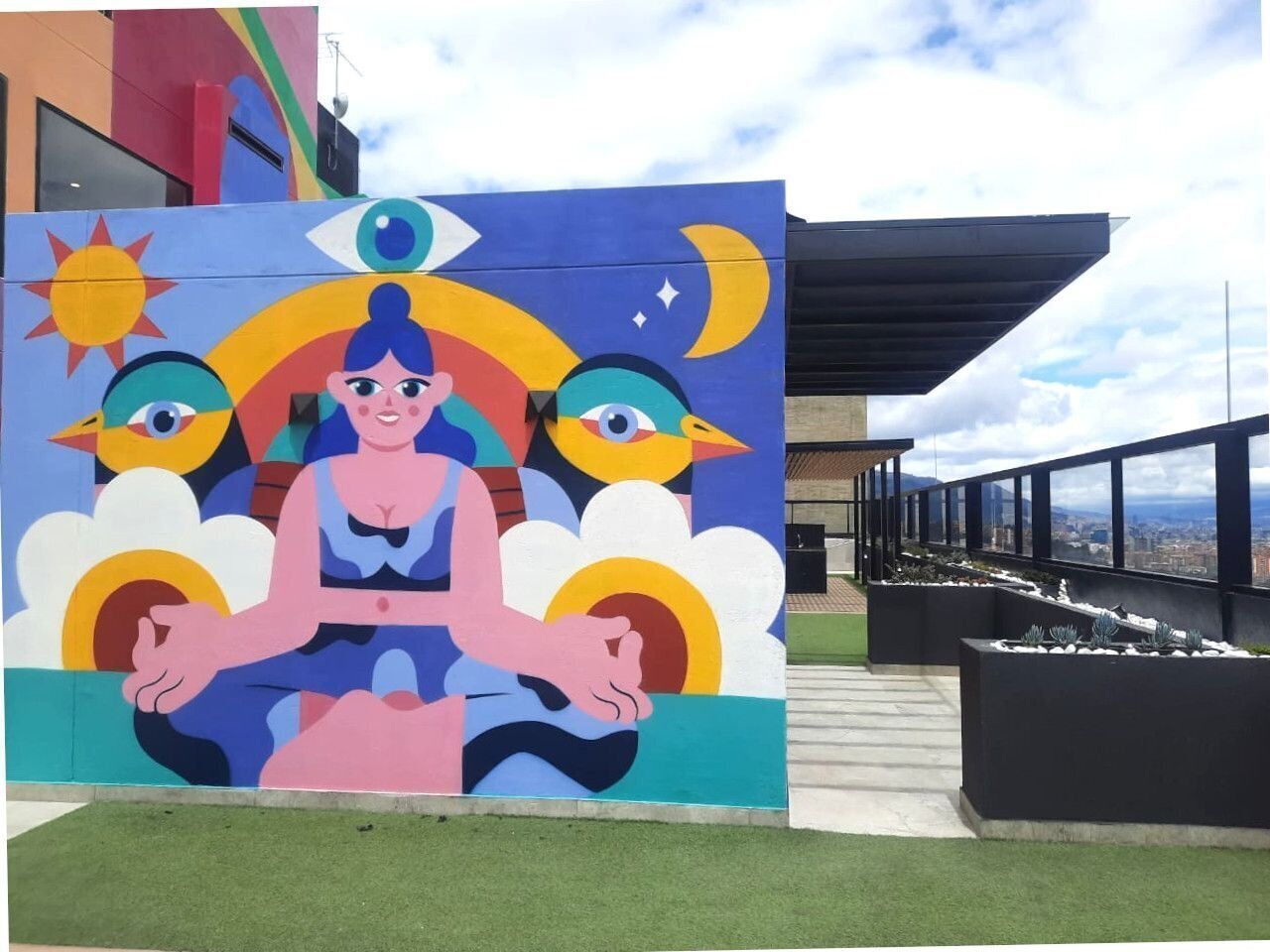 A mural with a central figure surrounded by birds and celestial elements.