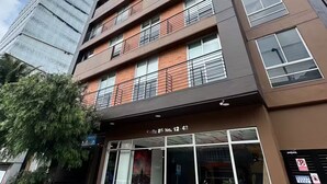 A modern multi-story building with a ground-level entrance, large windows, and a visible storefront. - The best apartment in the best area of Bogota (Bogotá)
